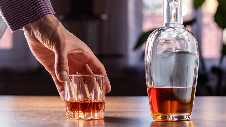 hand with whiskey glass