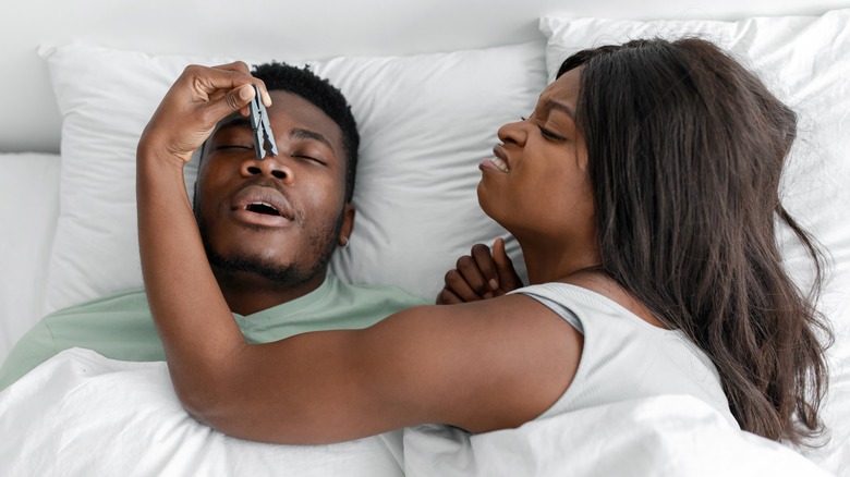 woman trying to stop man snoring