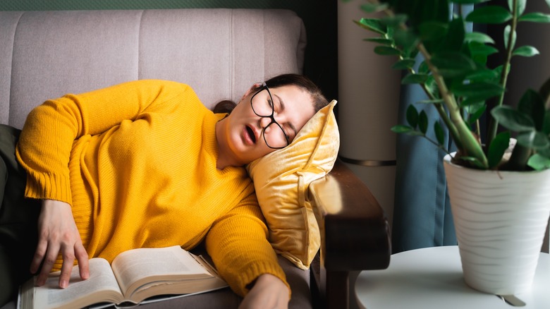 woman asleep on couch reading