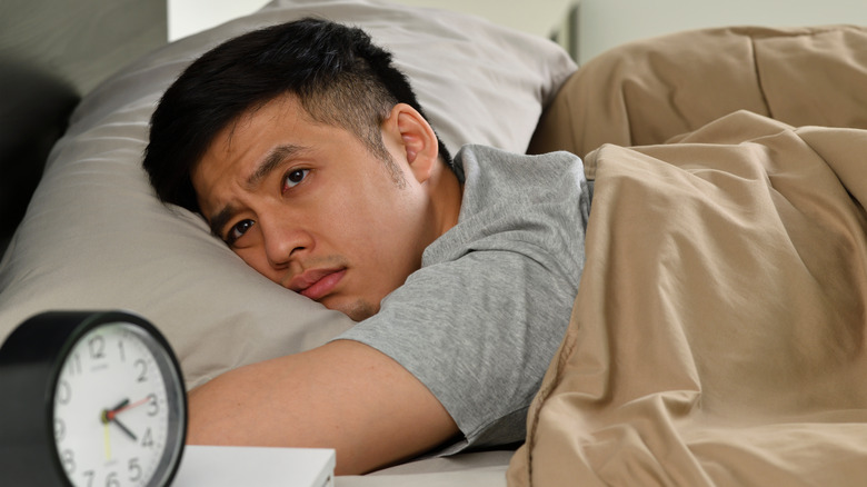 man with insomnia in bed