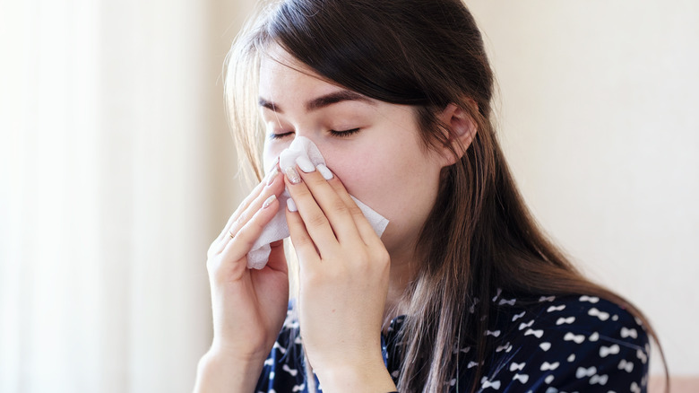 Woman sneezing from seasonal flu