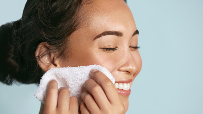 Woman removing makeup with towel