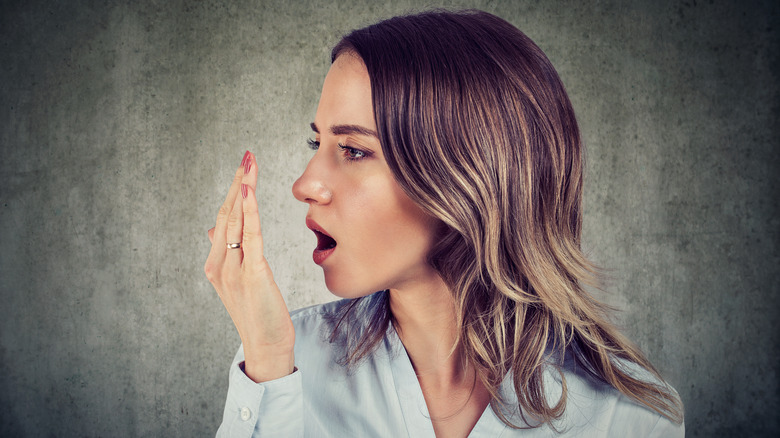 woman checking her breath odor