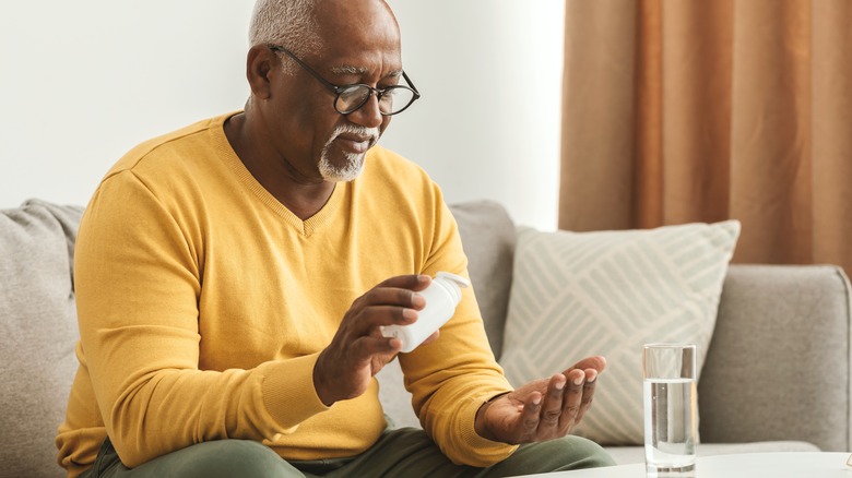 Man putting pills in hand