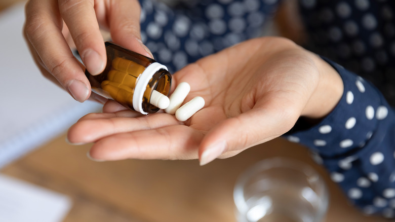 Woman pouring pills into palm