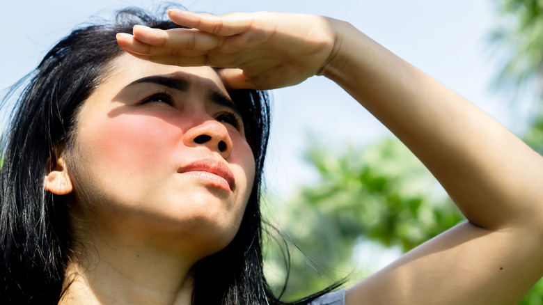 woman shielding face from sun