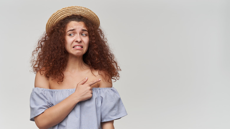 woman pointing to shoulder