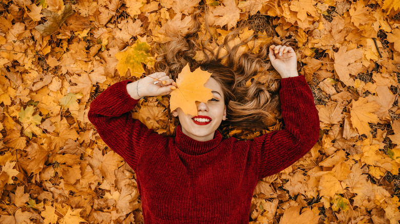 woman in fall leaves