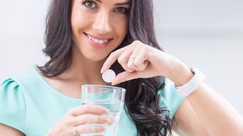 smiling woman with magnesium tablet