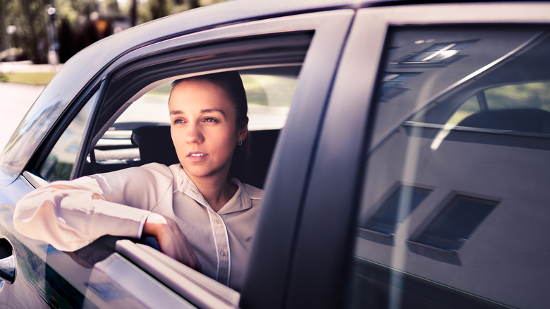 a pensive person in the back seat of a car