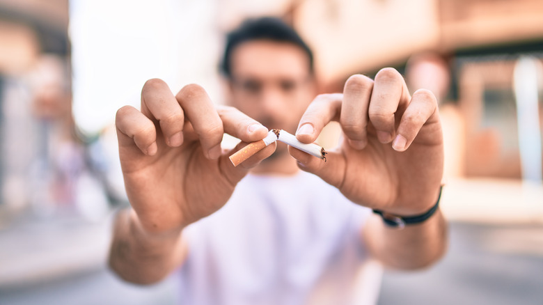 man breaking cigarette