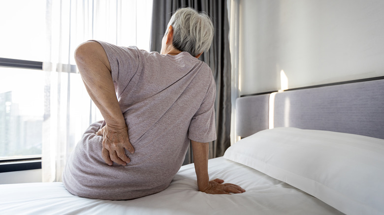 older woman holding hip