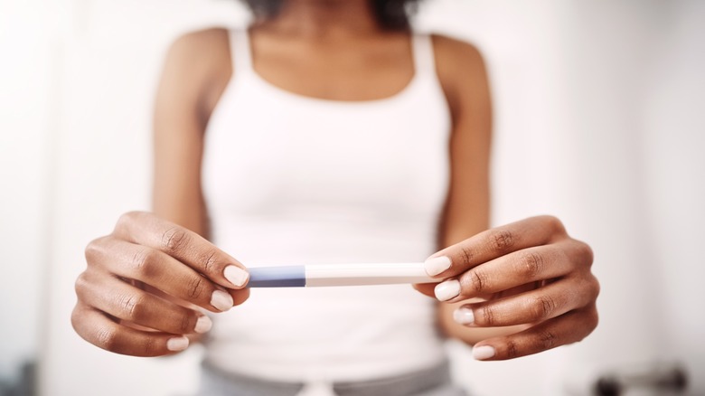 woman holding a pregnancy test