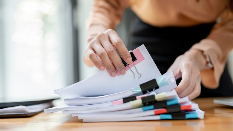 woman organizing paperwork pile