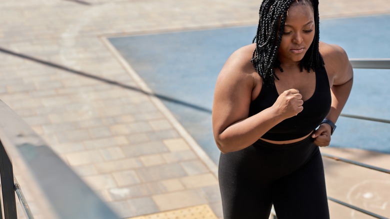 woman in fitness gear running up stairs