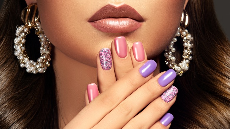 woman's face with lipstick, manicured nails