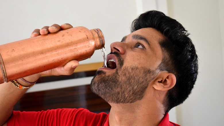 man chugging water