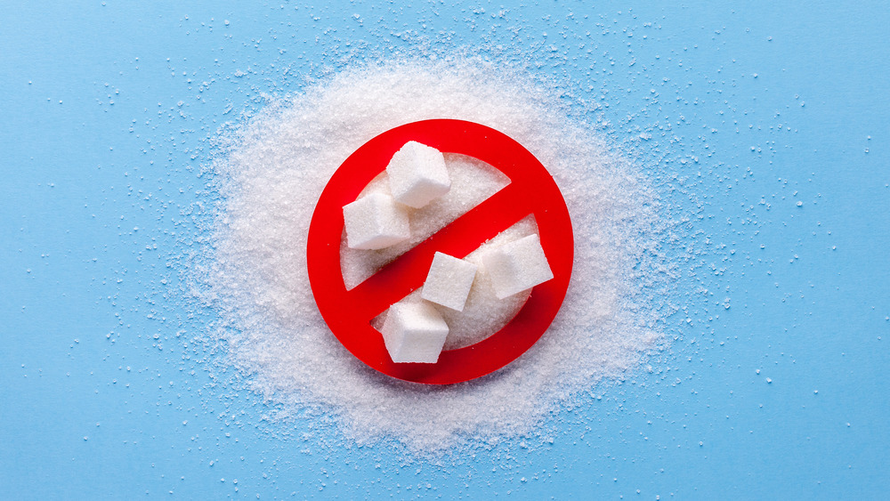 Five sugar cubes on a pile of sugar with a red circle with a line through it