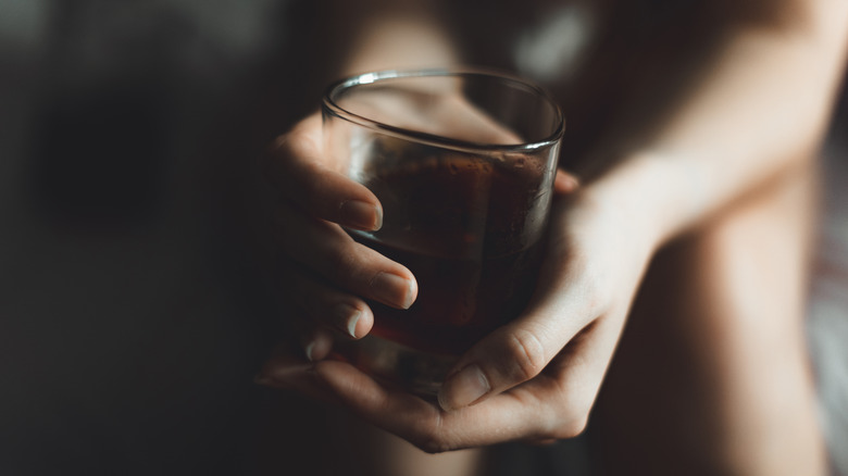 woman's hands holding alcohol glass