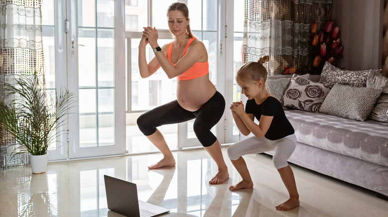 pregnant woman exercising with child