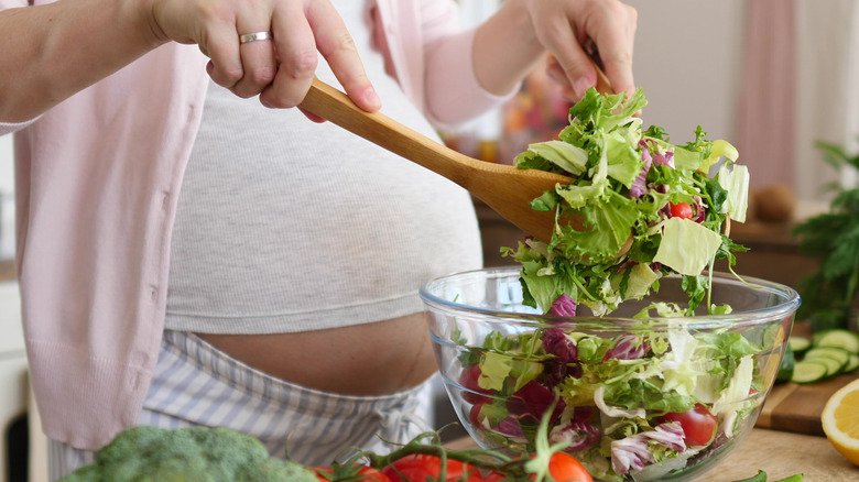 pregnant woman making salad