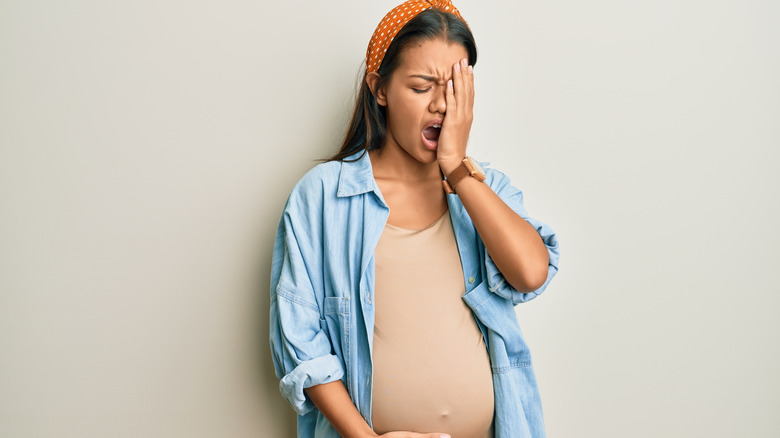 exhausted pregnant woman yawning