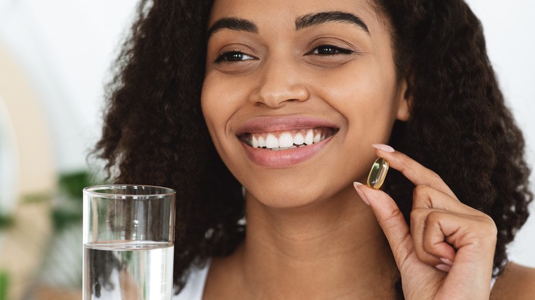 woman taking supplement tablet