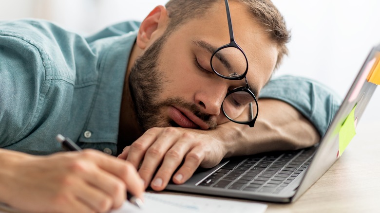 man falling asleep on laptop