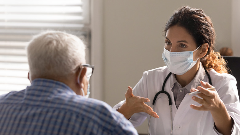 senior citizen talks with female doctor