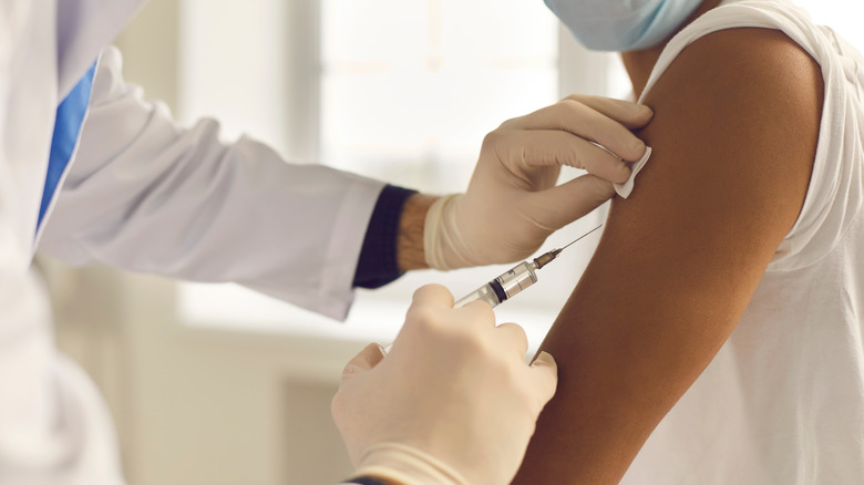 doctor vaccinating into arm of patient