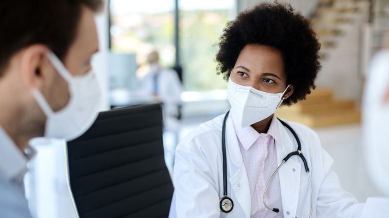 patient having consultation with masked doctor