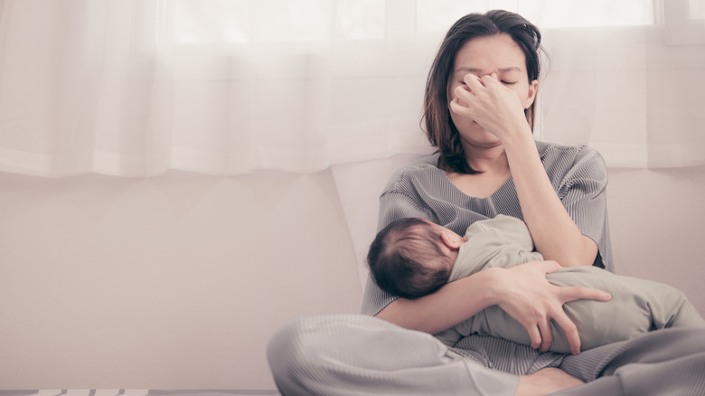 stressed mom breastfeeding newborn