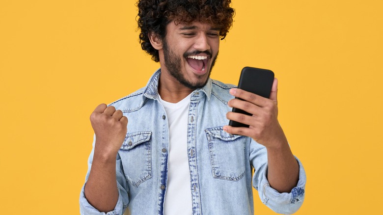 man happily holding phone 