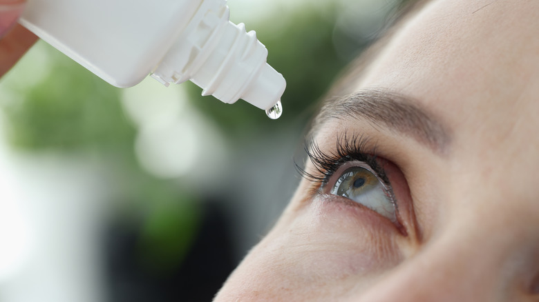 Woman putting eyedrops in her eye