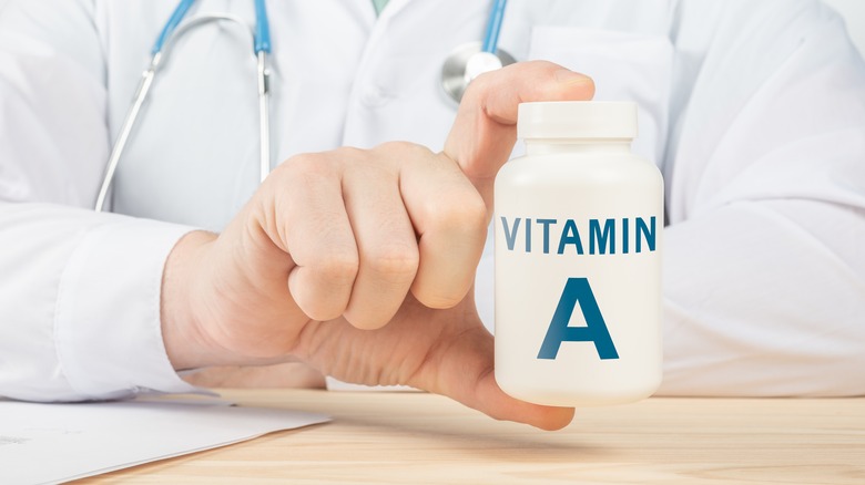 doctor holding bottle of vitamin A