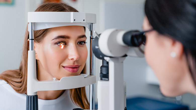 Woman getting eyes checked by doctor