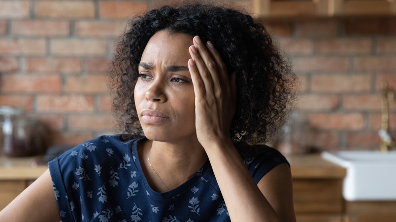 Stressed woman with hand on face