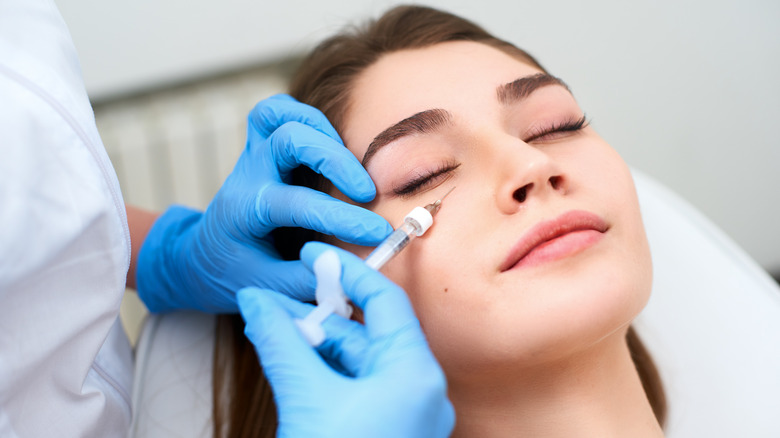 Woman getting injection near eye