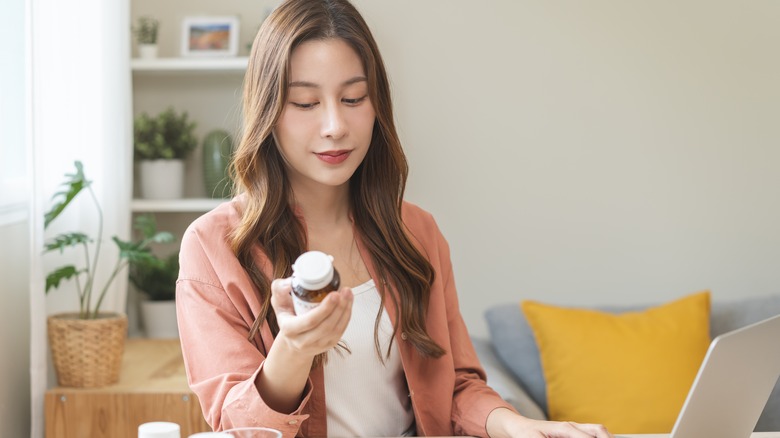 Young woman reading a medicine bottle