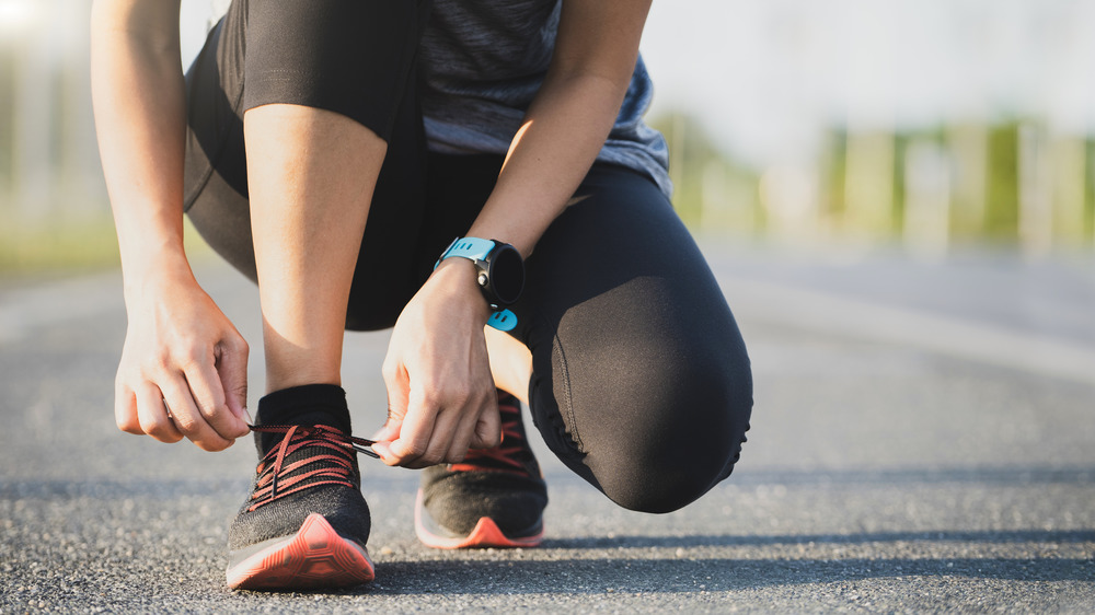 Woman lacing up her shoes to begin a run 