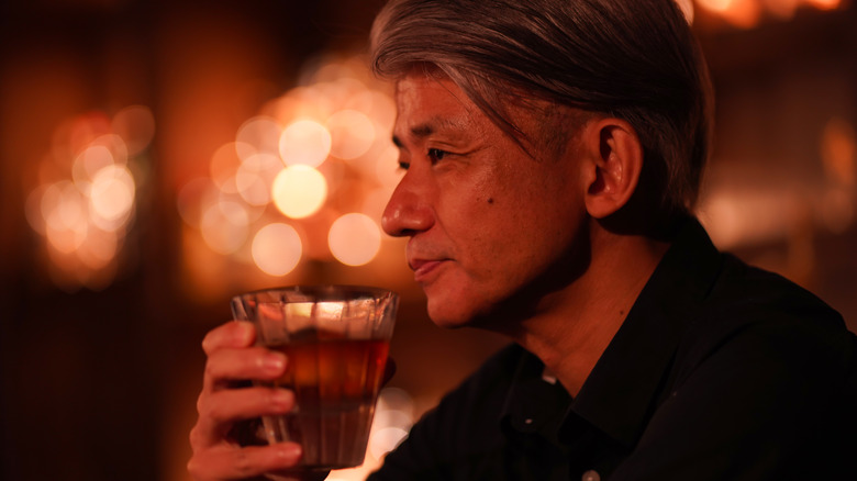 Man drinking alcohol at bar in evening