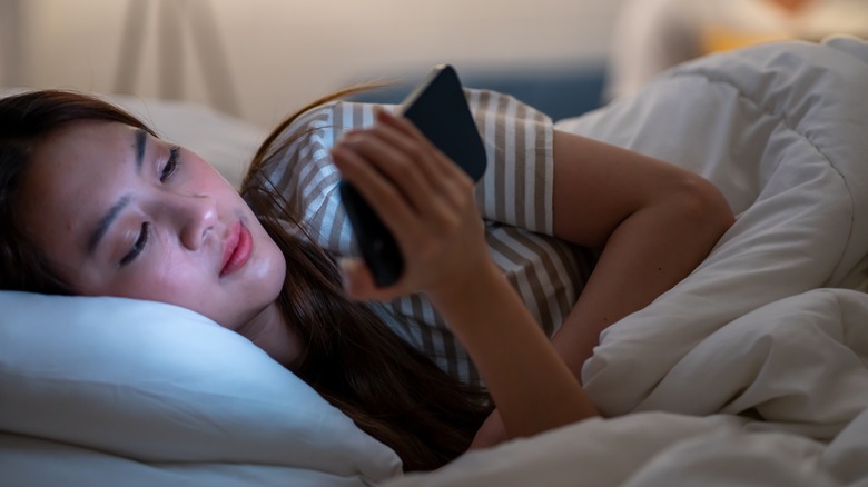 Woman in n bed checking device