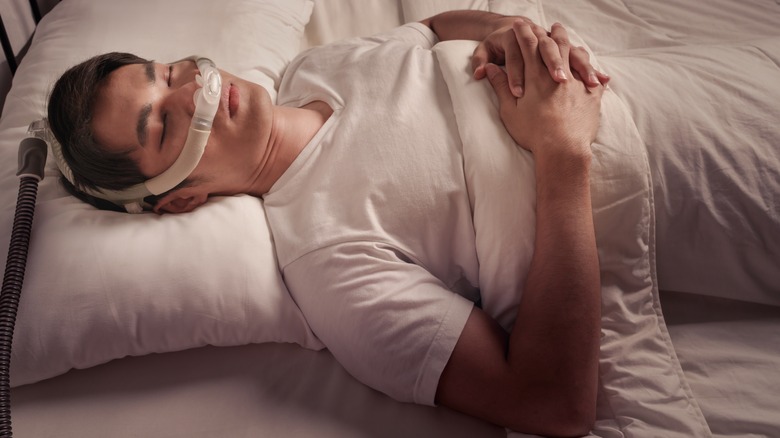 Man in bed with CPAP machine for apnea