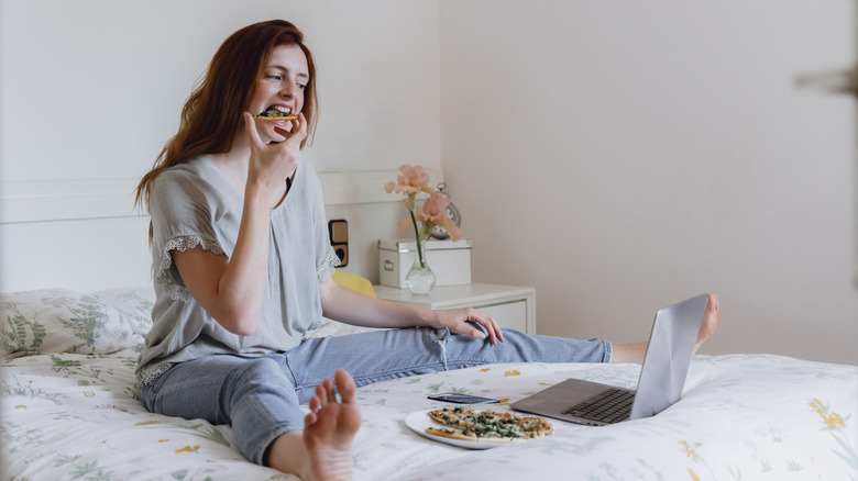 Woman eating food in bed