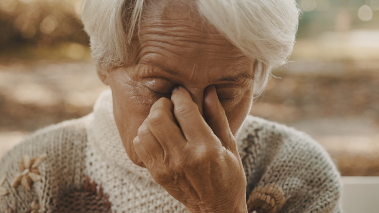 Older woman rubbing eyes