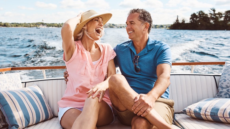 happy older couple sitting on the back of a boat