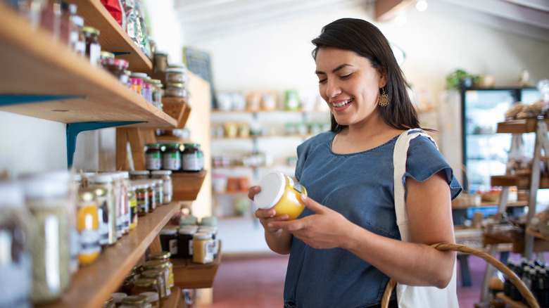 woman looking at the label of a canister in the store