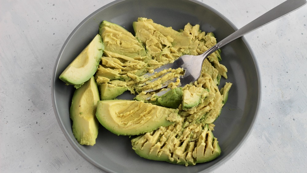 Mashed ripe avocados for healthy egg salad