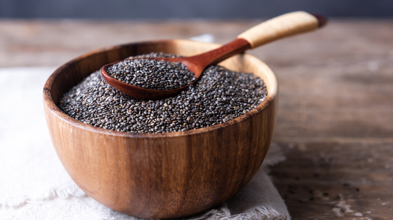 Chia seeds in a wooden bowl with a wooden spoon