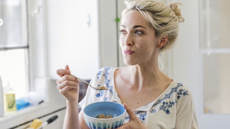 A woman eating a healthy breakfast from a bowl